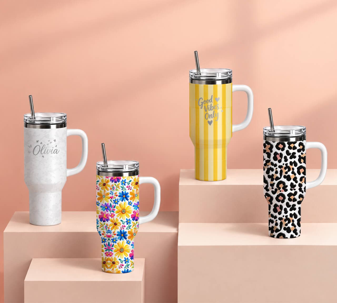 Colorful custom printed handled tumblers displayed on blue studio platforms